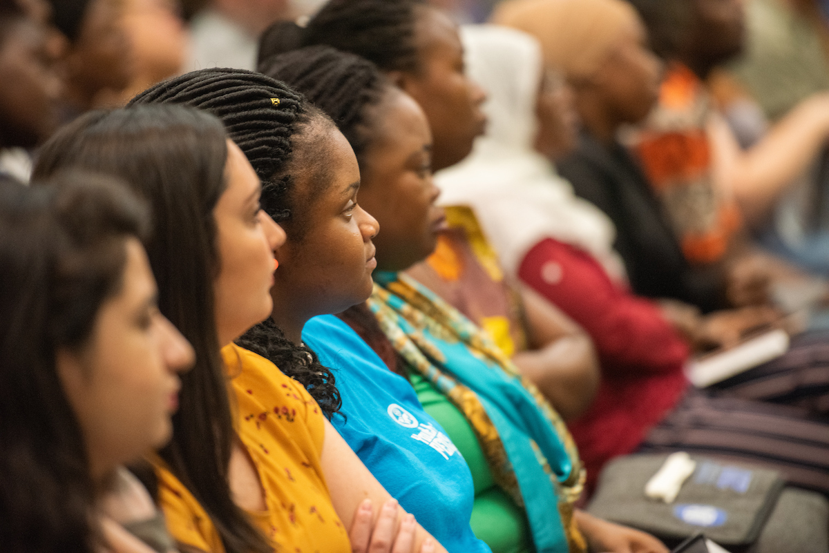 Graduate students listening to a speaker at orientation