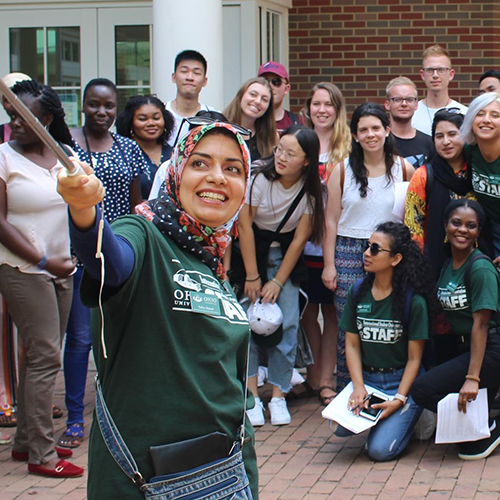 International students and faculty pose for a selfie in front of Baker University Center